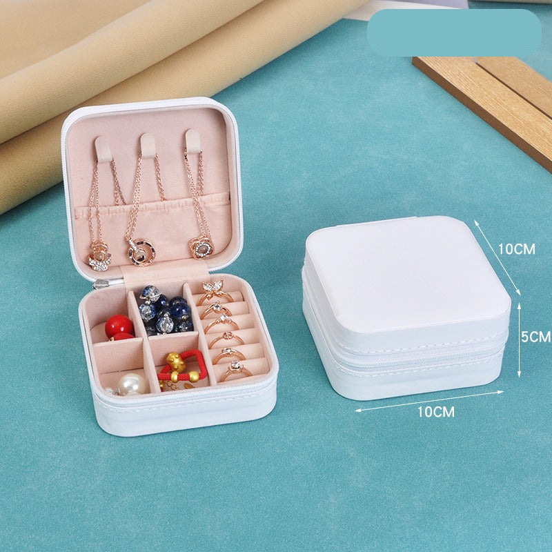 Jewelry organizer with compartments on a blue surface, showing dimensions.